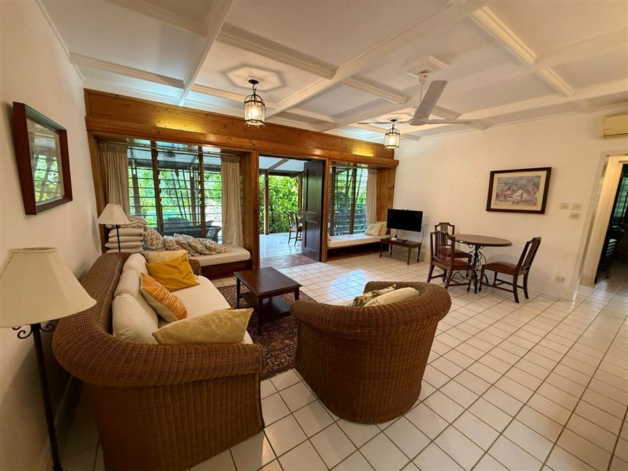 Living room with cane sofas and doors open to the veranda