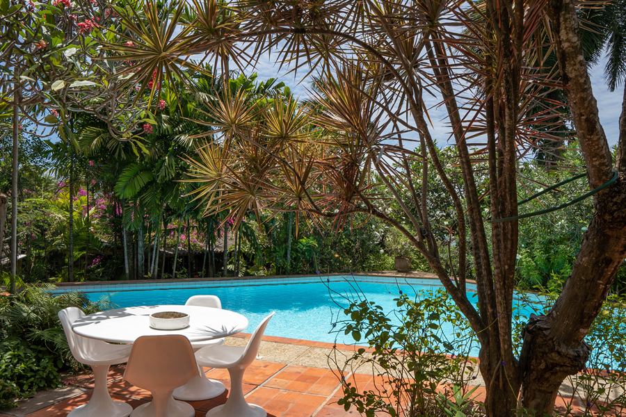 A white table and chairs beside the terrace pool