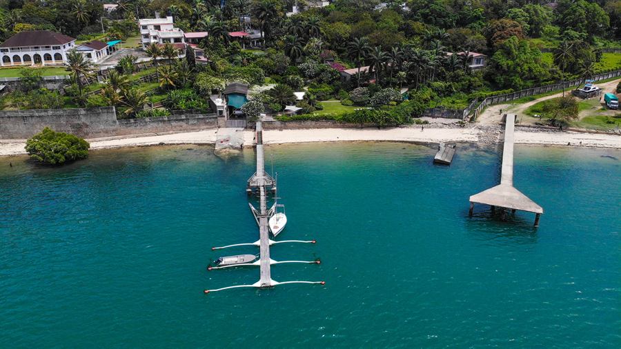 The pontoon moorings and jetty seen from out on the creek, with the gardens behind